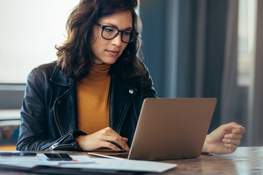 School communication professional working at a laptop